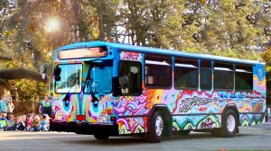 An exterior shot of a tie-dye-painted bus parked on the street
