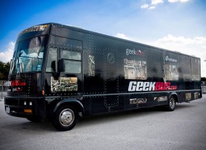 An exterior shot of a large black RV that says Geekbus on the side