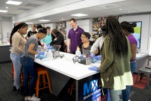 A group of students are working in a science lab within a double-expandable trailer.