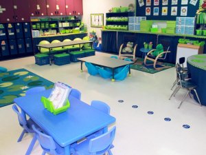 A classroom filled with different height tables and seating options, like rocking chairs and crate chairs.