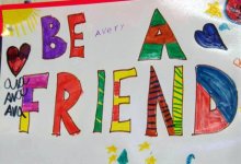 A poster pinned on the wall drawn by students that says "Be A Friend"