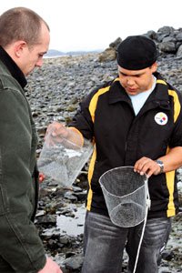 Boy and teacher looking at a crab trap