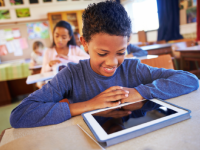 A photo of a middle-school student working on a tablet.