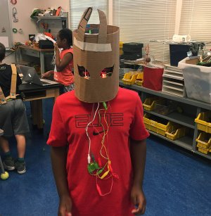 A student poses in a cardboard helmet.