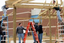 Students and community members framing a building.