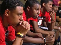 Young black men sitting in a row