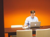 Teacher sitting alone working on laptop