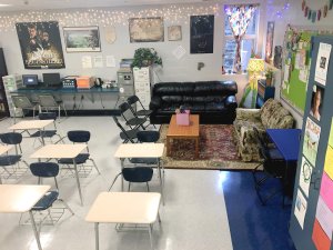 A classroom filled with desks, couches, and home furniture