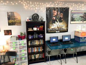 Bookshelves, storage bins, and a computer station against a classroom wall