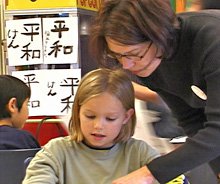 Parent volunteer standing over a girl.