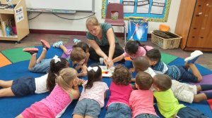 Audra Damron works on the floor with pre-K students.