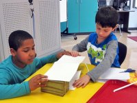 Two boys working with paper and scissors