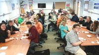 A high school class at Compass Academy sitting around banquet tables.