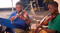 Photo of two boys playing violins