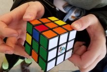A pair of hands holding a Rubiks cube