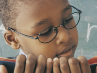 A photo of a young boy reading a book.