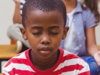 photo of a young boy sitting with eyes closed