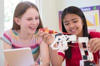 Two Female Pupils In Science Lesson Studying Robotics