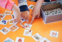 Elementary school students point to card with photos and words during a game