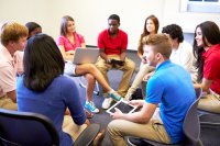 High school students sitting in a circle and taking part in a group discussion.