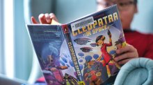 Elementary student reads a graphic novel at home