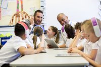 Two teachers working with a group of students in a classroom