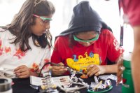 Two middle school students working on a robotics project