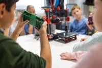 A group of students working with a 3D printer