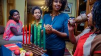 People gather at a table to celebrate Kwanzaa.