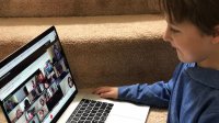 Boy participating in a video chat with his class