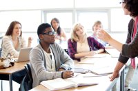 Teacher talking to a class of engaged high school students.