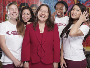 Four girls standing around woman smiling