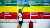 Teacher pointing to a wall of color coded cards