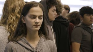 A close-up on high school students standing back-to-back with their eyes closed.