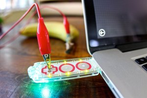 Photo of a Makey Makey device attached to a laptop and a banana.