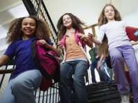 Three young students walking down school stairs