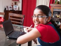 Girl working on her laptop at home on the dining room table