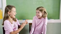 Two second-grade girls role-play a scenario.