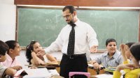 A teacher guides young students out of a moment of conflict.