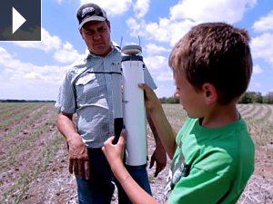 Cort and his father check a tool on their Nebraska farm. 