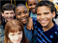 Two girls and three boys standing together smiling