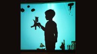 Silhouette of a boy holding a paper puppet
