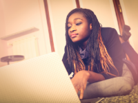 A photo of a high school female doing research on her  laptop.