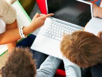 Three people around a laptop