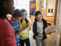 Four girls working as a team in front of a whiteboard