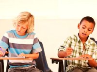 Two boys writing at their desks