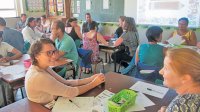 A classroom filled with teachers talking to each other while seated