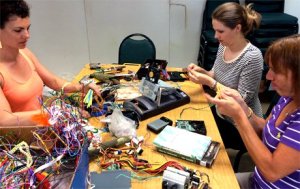 Three teachers sitting together at a table working with cords and circuits