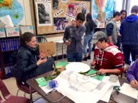 Two boys and a girl around a table working on a project