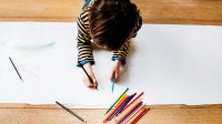 Photo of pre-k child drawing on paper